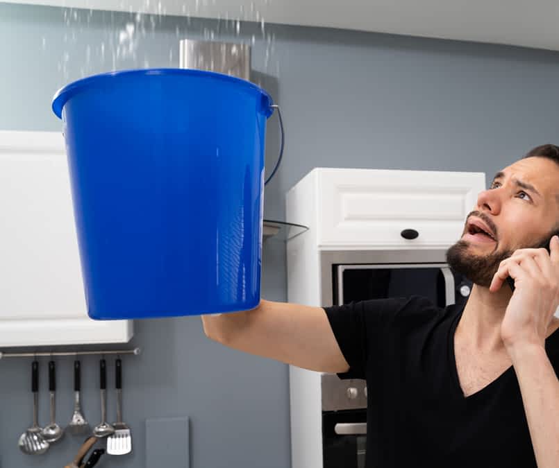 Tips for Water Damage Restoration - A Man Holding a Bucket Under a Leak Coming from the Ceiling