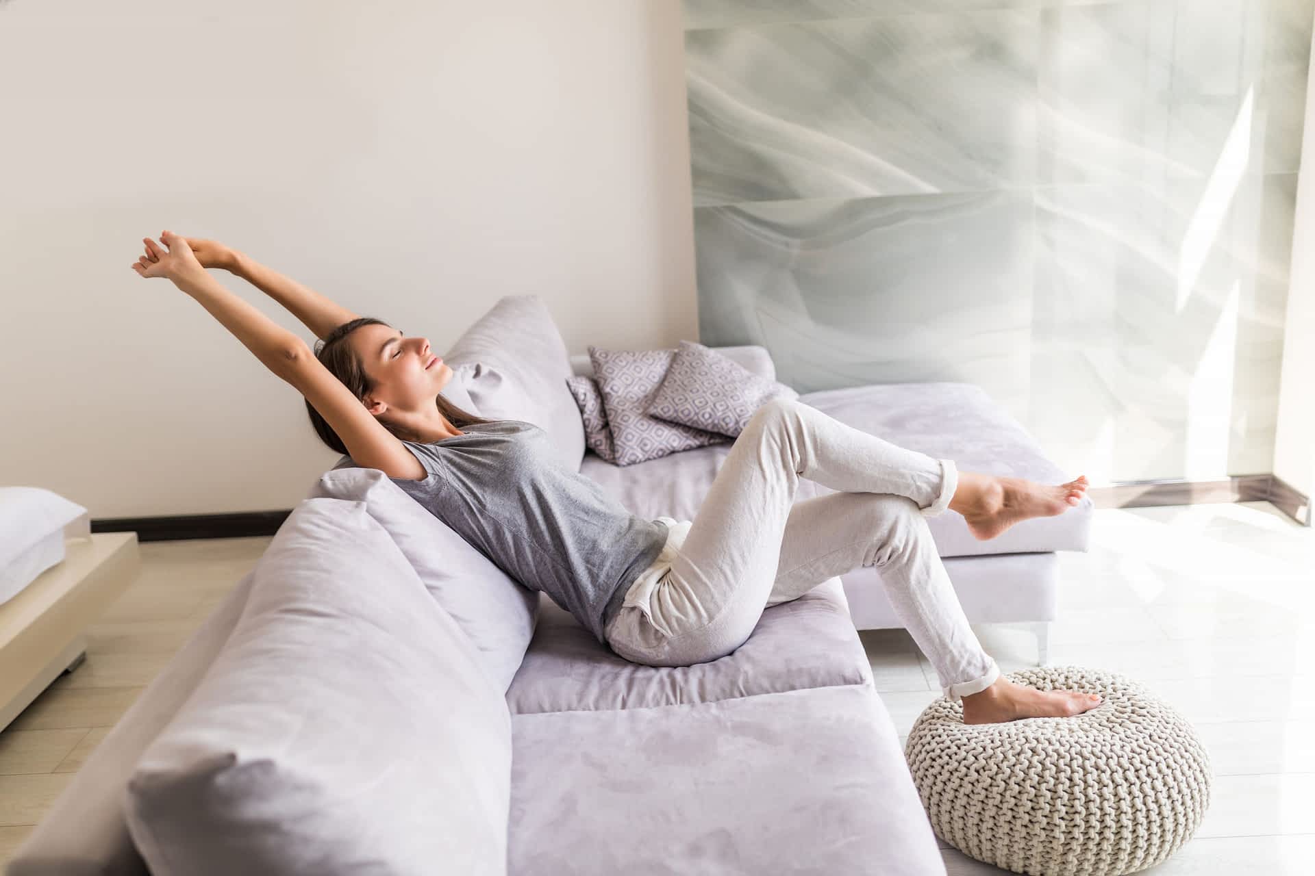 Air Purification Contractor New York - A Woman on Her Couch Stretching