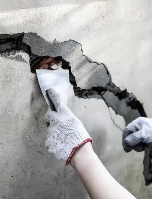 Basement Cracks Repair Contractor New York - A Construction Worker Fixing a Crack in a Basement Wall