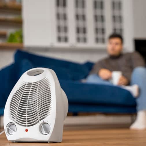Dehumidification Contractor New York - A Man Relaxing on His Couch with a Coffee and an Air Purifier in Front of Him on a Table