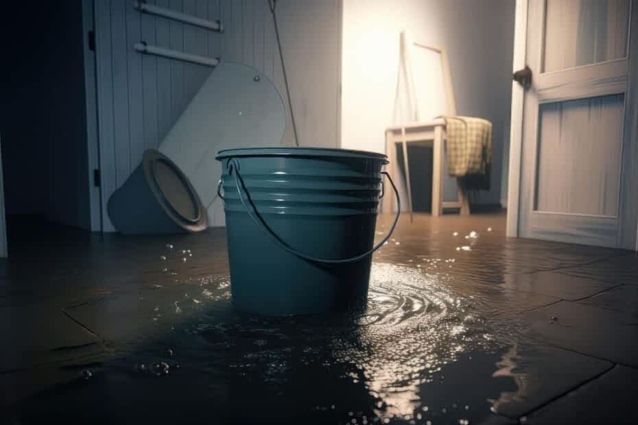 Water Damage Cleaning Contractor New York - A Bucket Sitting on a Kitchen Floor Catching Water from a Leak